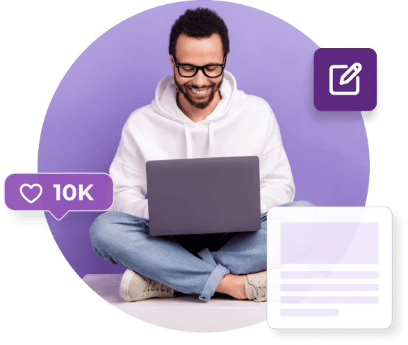 A man in a white hoody and jeans sits cross-legged with his laptop next to a heart that says 10k.