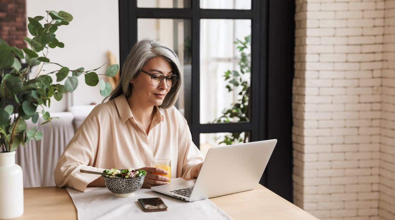 Image of Caucasian woman working at her laptop and looking for a CRM software for her business.