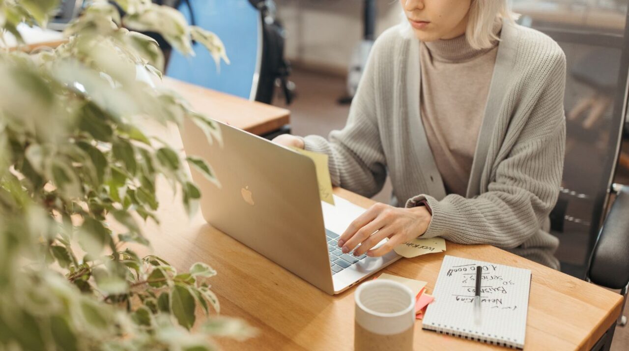 Woman taps on laptop with coffee nearby, trying to determine if her email list is healthy.