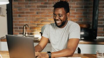 Young bespectacled man understands email authentication after looking at laptop.