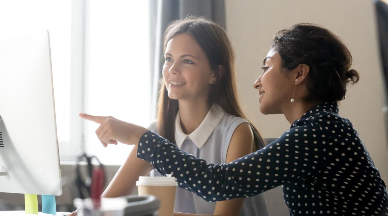 woman colleagues working in front of computer learning about things to avoid when sending bulk emails