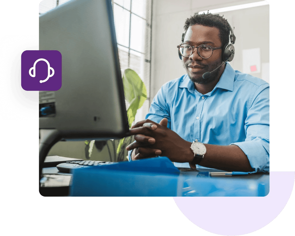 Customer support agent wearing a headset looking at his computer