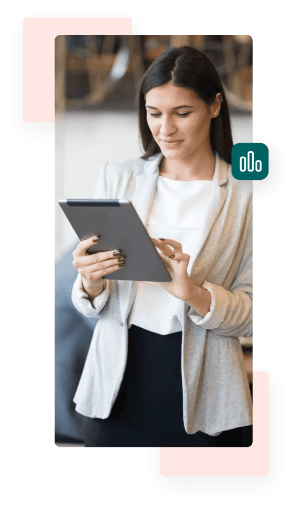 A businesswoman wearing a white top and beige blazer smiles slightly while holding and typing on a tablet.