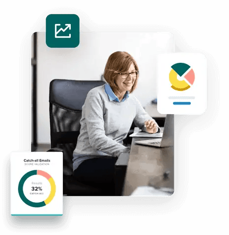 Woman sitting at a desk smiling and looking at her laptop using ZeroBounce Catch all emails to increase her email ROI.