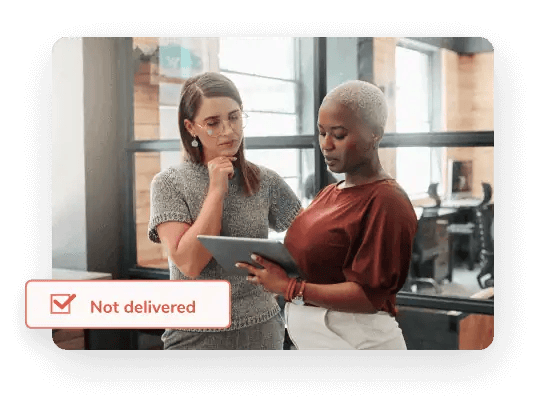 Dos mujeres colegas miran una tableta que muestra un informe que evalúa la degradación promedio de la lista de correo electrónico para promover la conservación de la lista de correo electrónico.