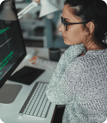 A woman in glasses looks at her Mac next to a revenue chart trending upward.