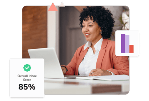 A woman in a white shirt and pink jacket looks at her laptop to see an overall inbox score of 85% for her email warmup.