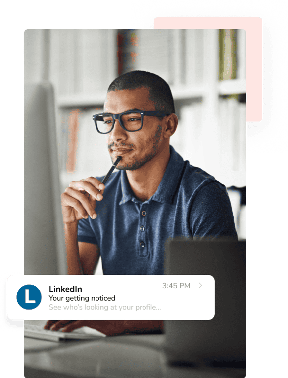 Un hombre con gruesas gafas negras y una camiseta de cuello polo azul se toca la barbilla con el bolígrafo mientras revisa un correo electrónico de LinkedIn.