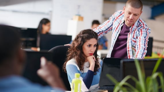 Two sales colleagues look over the computer to decide on a new CRM tool.