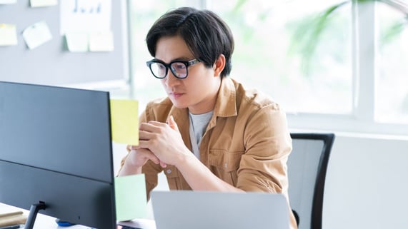 Young, bespectacled Asian man looks into his email warm-up portal and sees the improvement.